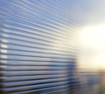 Blue surface of striped polycarbonate with a reflection of the blue distance of the city