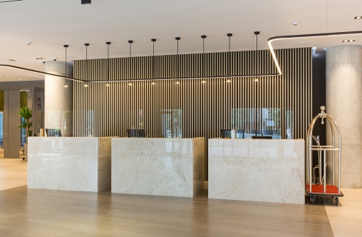 Interior of a hotel lobby with reception desks with transparent coronavirus plexiglass lexan clear sneeze guards