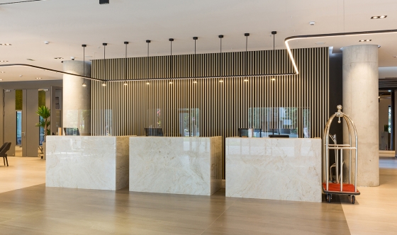 Interior of a hotel lobby with reception desks with transparent coronavirus plexiglass lexan clear sneeze guards